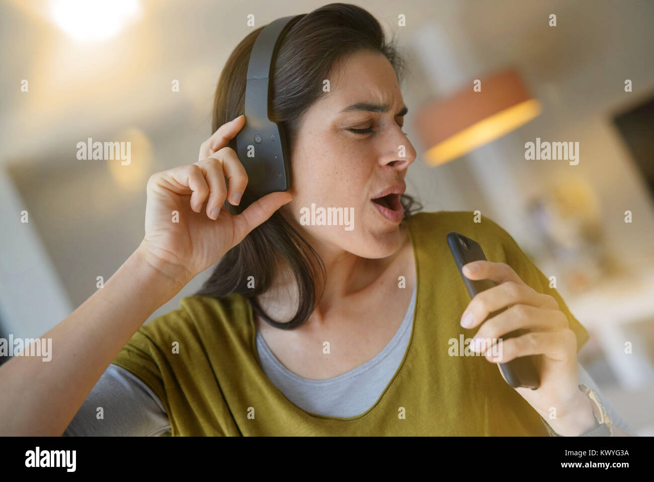Donna l'ascolto di musica con un auricolare bluetooth Foto stock - Alamy