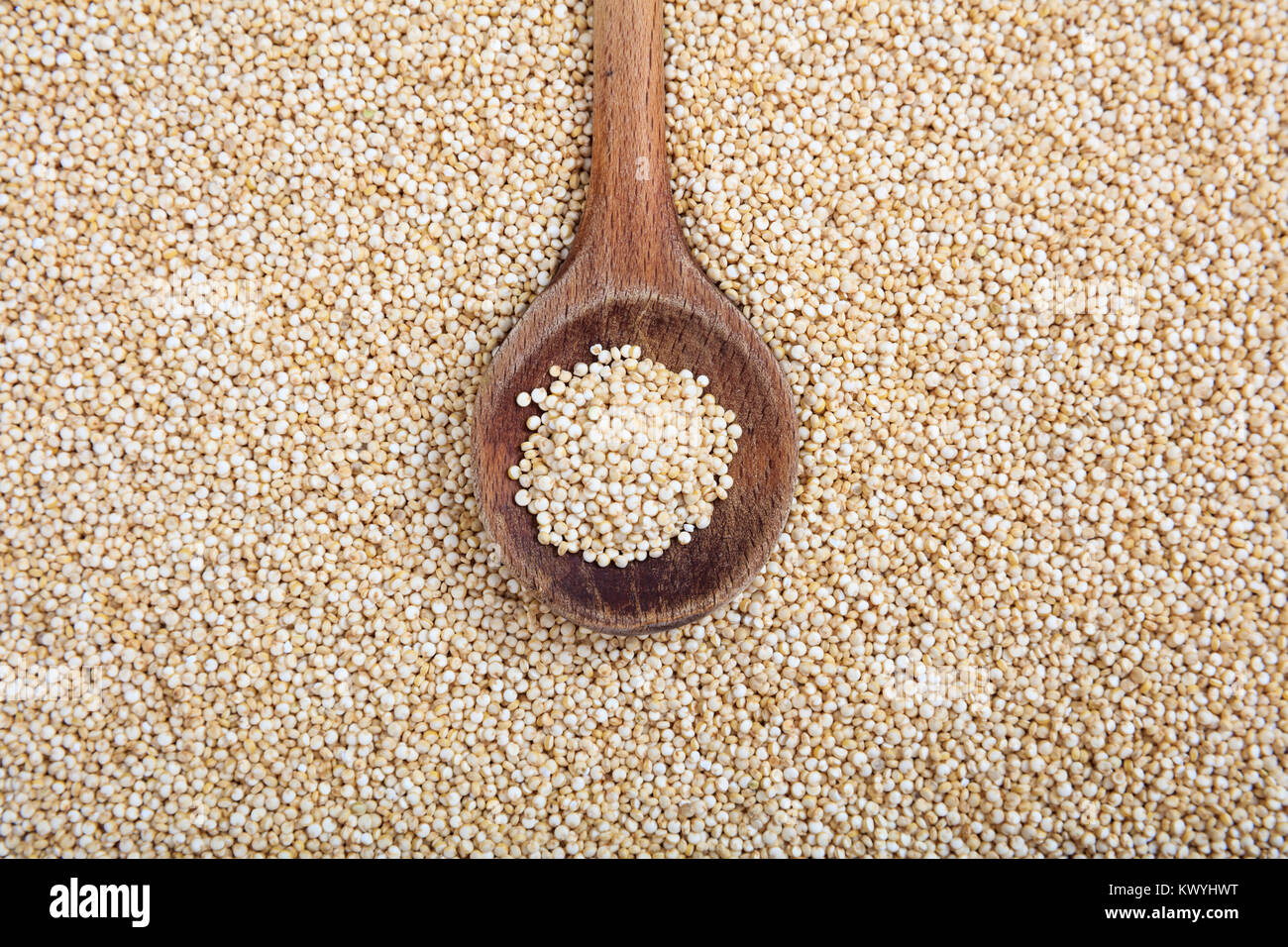 Cucchiaio di legno sulle materie di quinoa sfondo Foto Stock