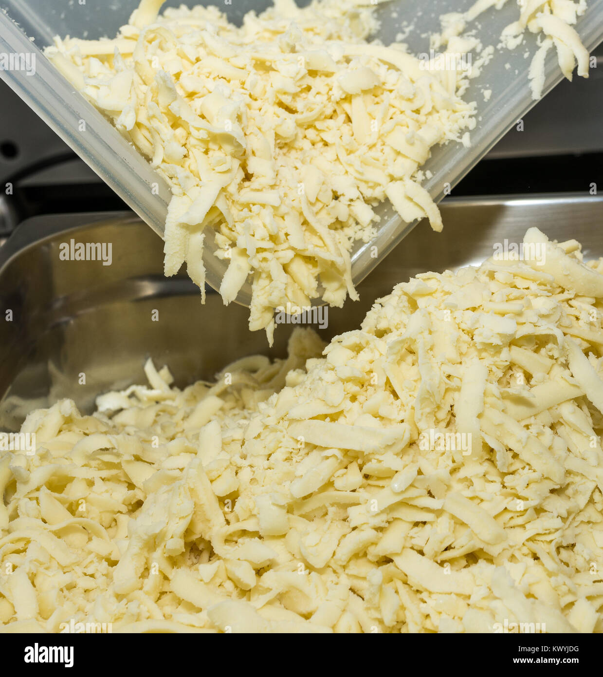 Tagliate il formaggio per pizza preparazione. Il cibo e la cucina italiana e il concetto di cucina a vista. Foto Stock