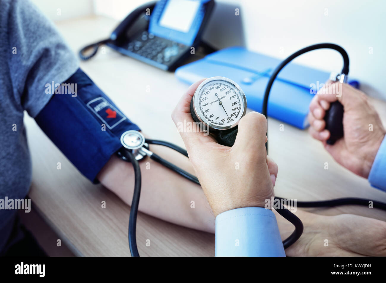 Medico controllando la pressione del sangue di un paziente Foto Stock