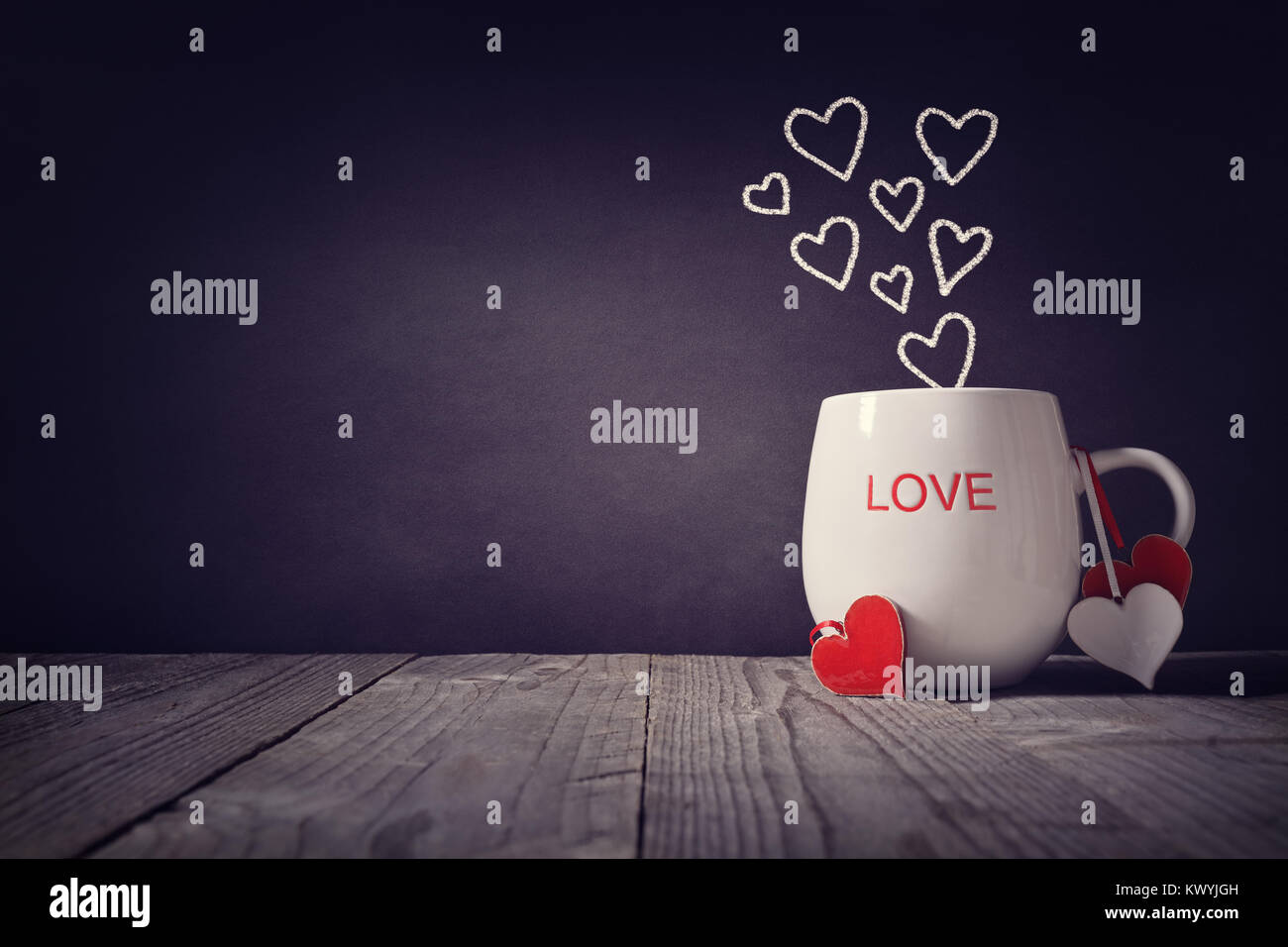 Amore scritto su una tazza con il concetto di cuori per il giorno di San Valentino o la festa della mamma sfondo con spazio di copia Foto Stock