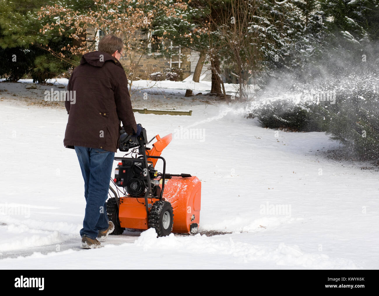 Un uomo lo sgombero neve utilizzando una casa spalaneve. Foto Stock