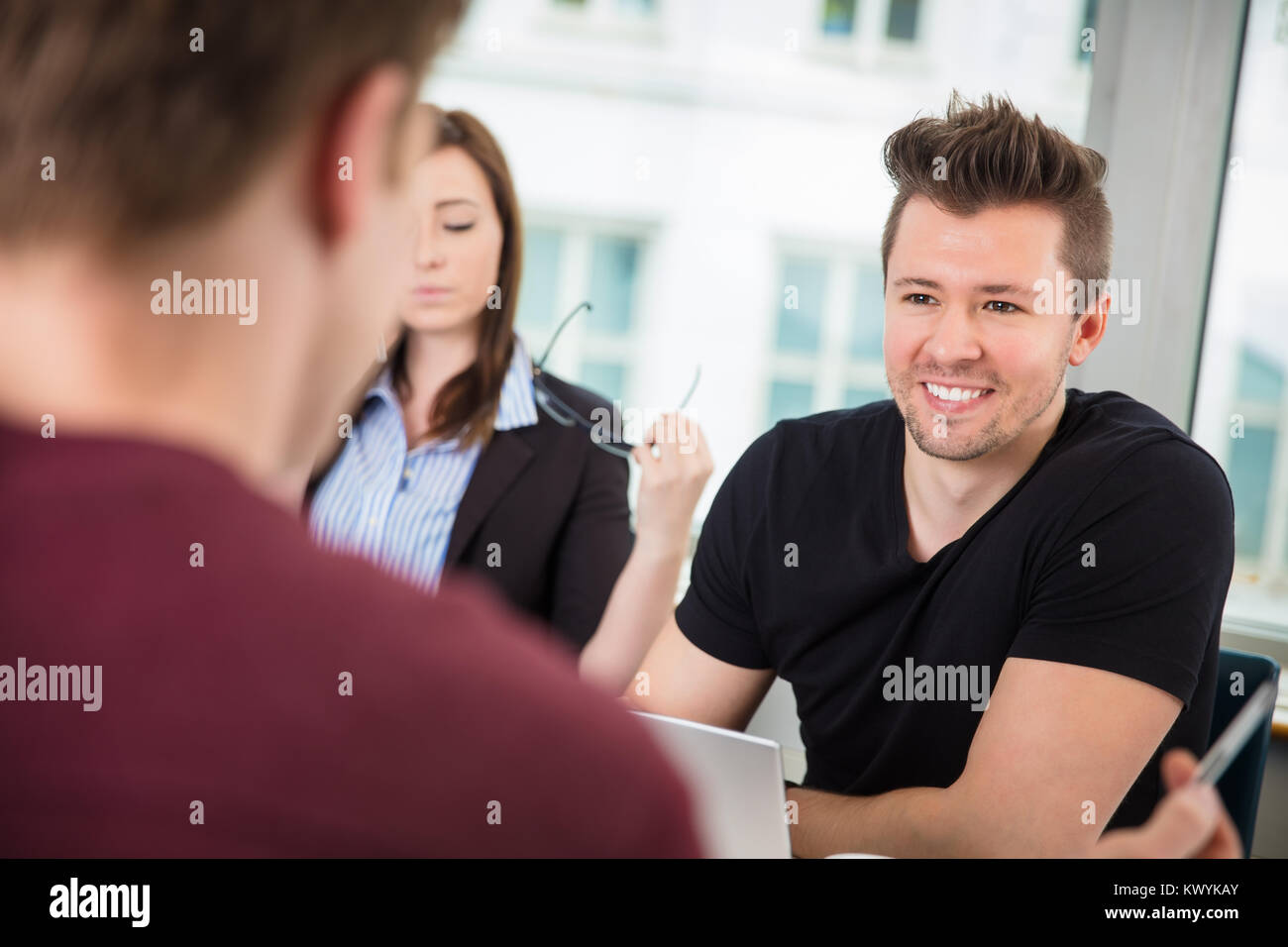 Imprenditore sorridere mentre guardando a un collega Foto Stock