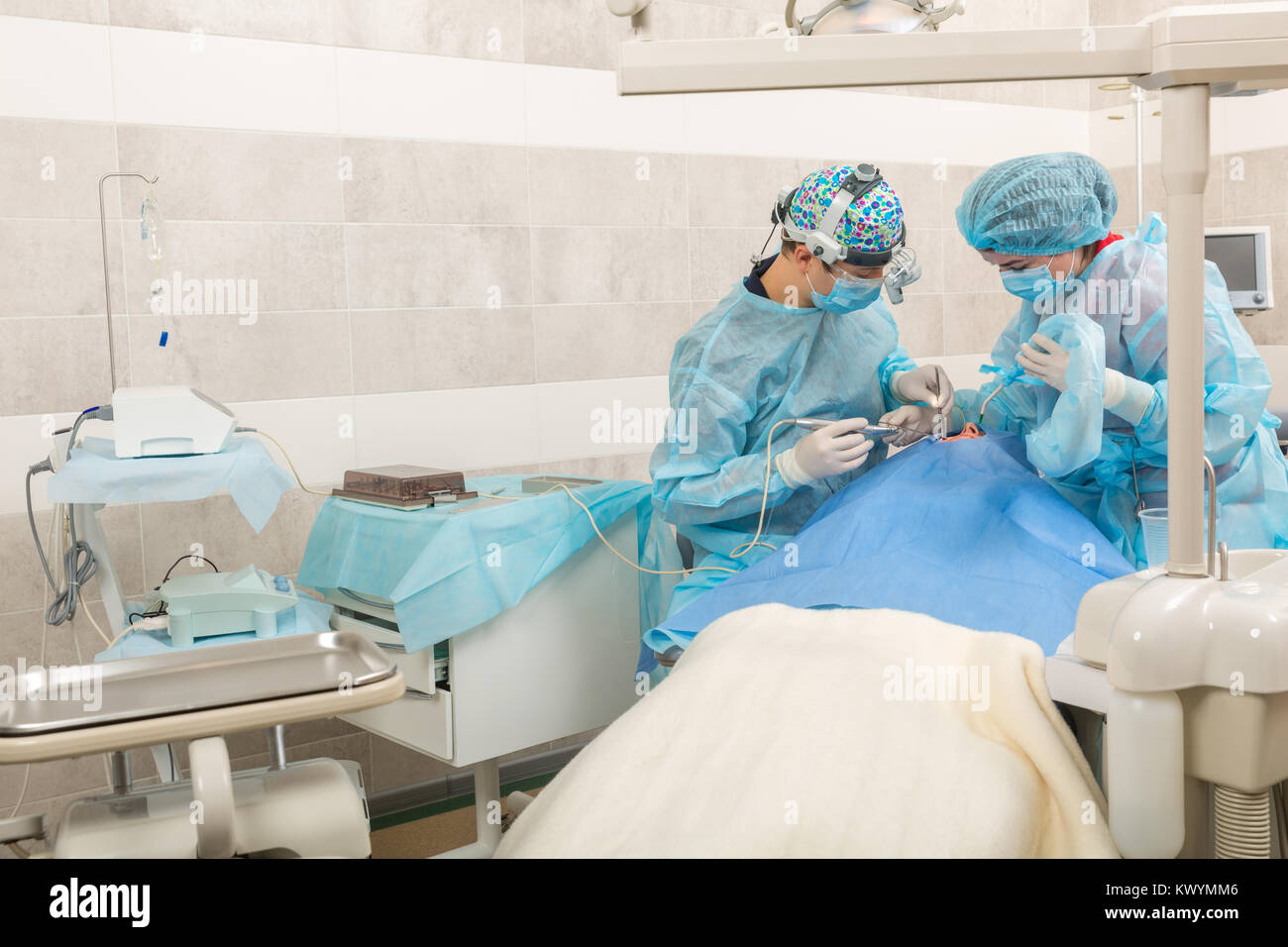 Dentista lavorare in team con paziente. chirurgia dentale. Dentista in maschera con lente di ingrandimento binocolo Foto Stock