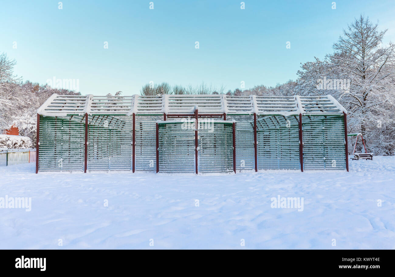 Metallo pallacanestro costruzione coperto di neve pesante Foto Stock