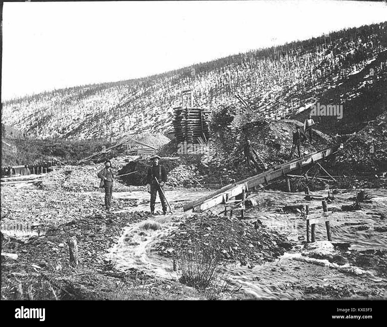 Fotografia che mostra i minatori che lavorano un canale a Hunker Creek nel 1899, illustra le tecniche minerarie e le pratiche di lavoro della fine del XIX secolo. Foto Stock