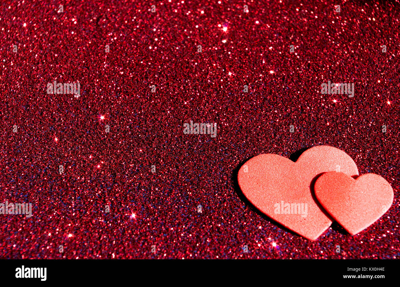 Due cuori rosso su rosso glitter Foto Stock