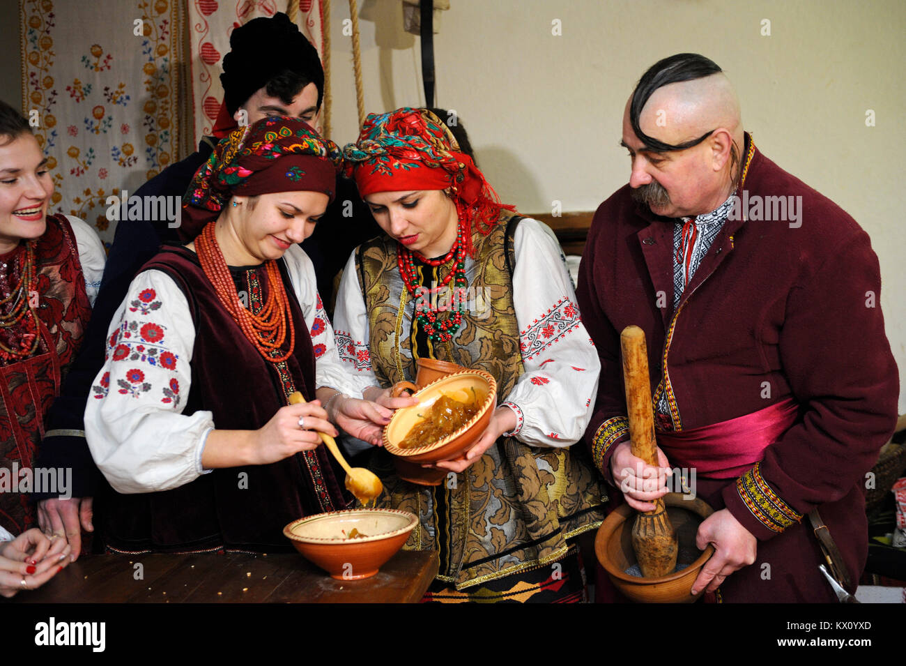 Persone in abiti nativo di preparare il piatto tradizionale "kutia" alla vigilia di Natale. La ricostruzione del folk ucraino tradizioni. Gennaio 4,2018. A Kiev, Ucraina Foto Stock