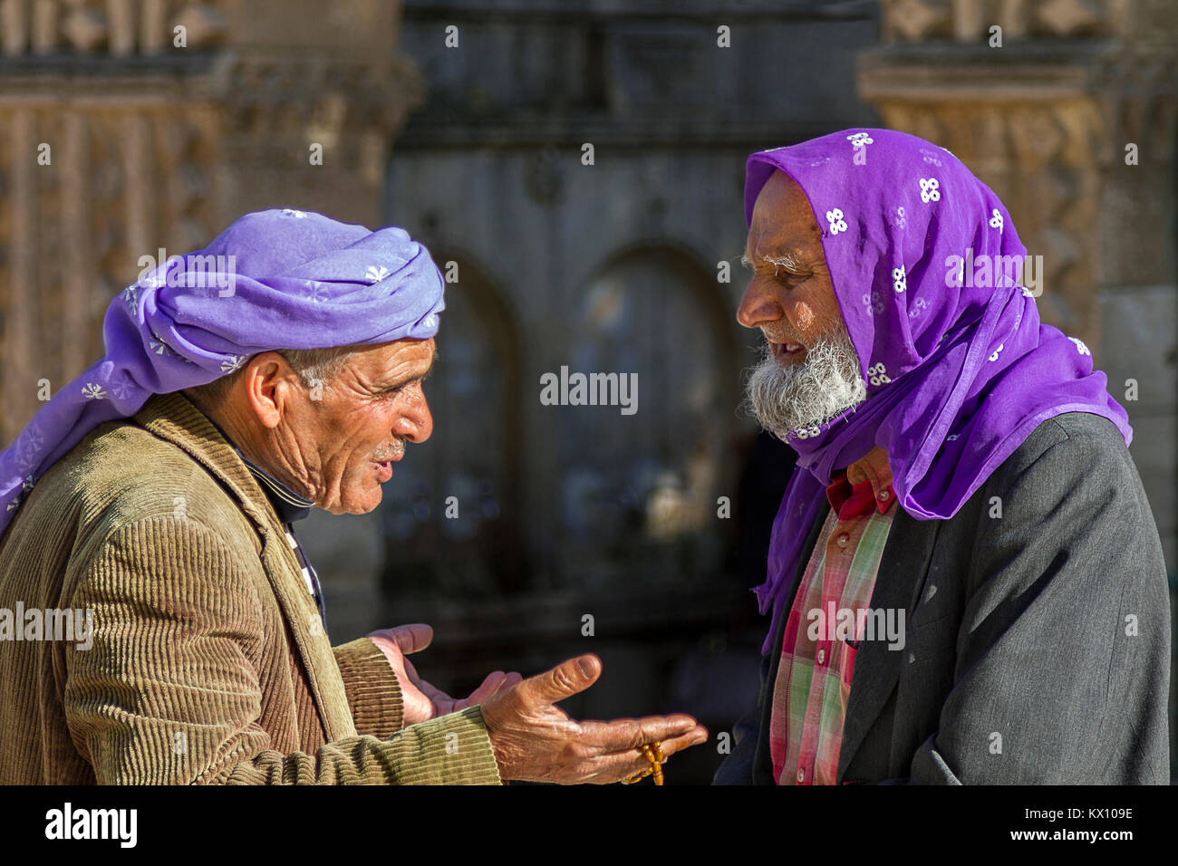 Gli anziani locali si comunicano tra loro a Sanliurfa, in Turchia. Indossano un tradizionale headdress viola. Foto Stock