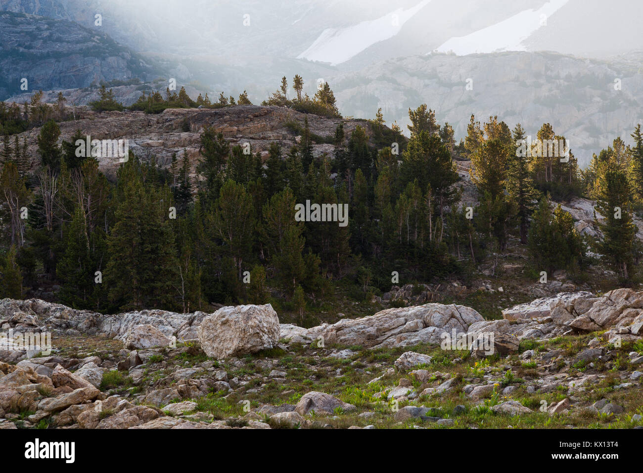 Affioramenti di impilamento di granito in strati vicino alla parte superiore della forcella del sud di Cascade Canyon nel Teton Mountains come alba illumina il backgrou Foto Stock