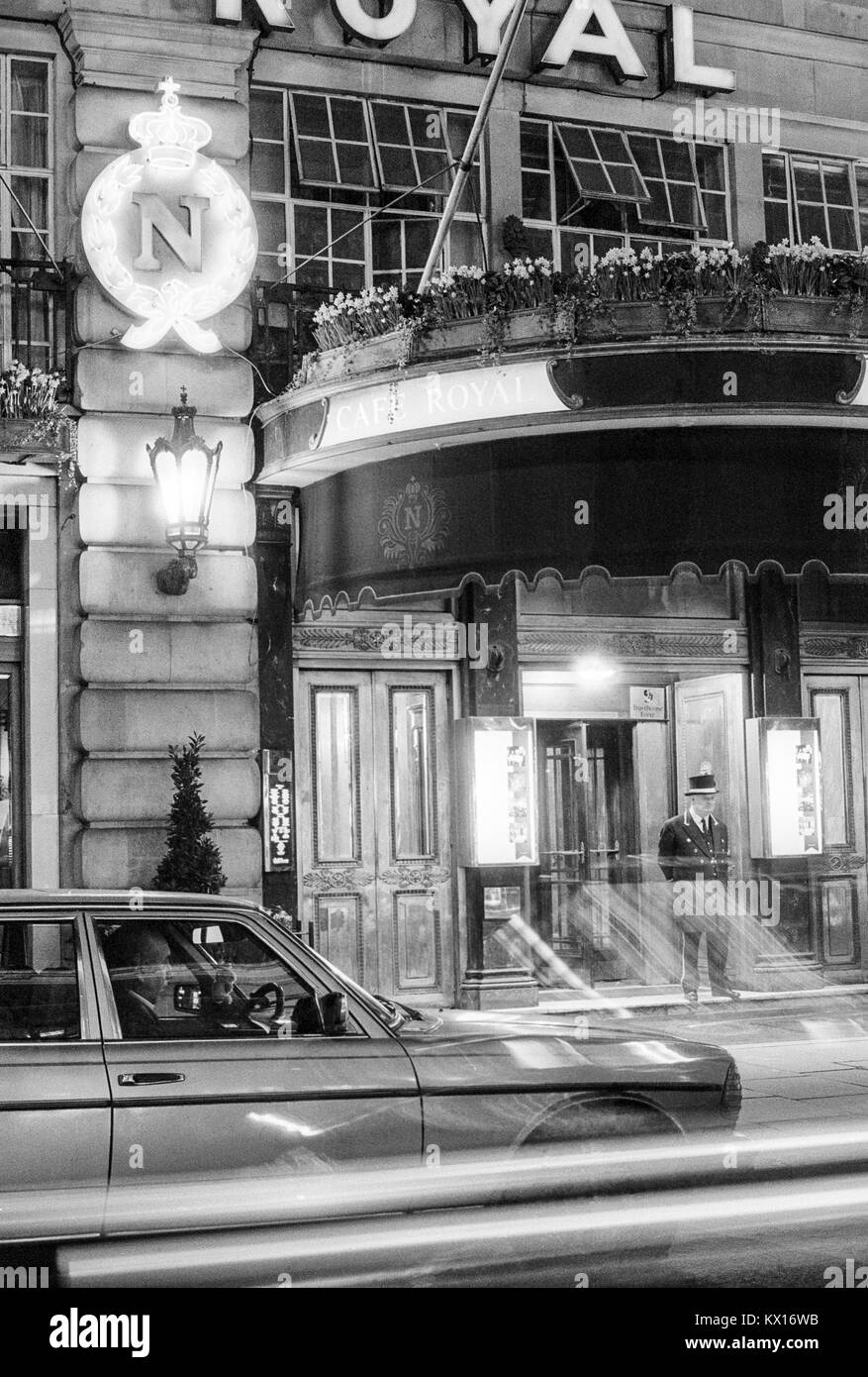 Il Cafe Royal su Regent Street, Soho, Londra di notte con il concierge, portiere si fermò sui gradini e sentieri di luce dal traffico in transito, degli anni ottanta Foto Stock