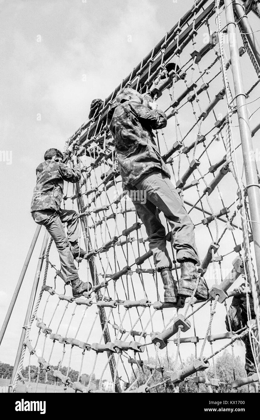 Esercito britannico squaddies sottoposti a formazione di base arrampicarsi sulla corda netting come parte di un percorso ad ostacoli, 15 giugno 1993 Foto Stock