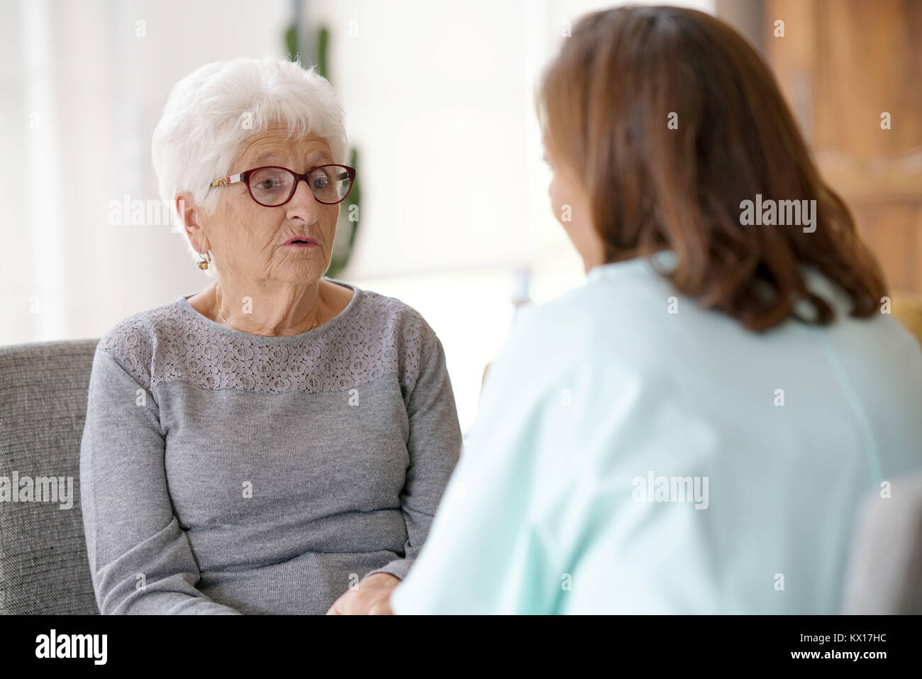 Infermiere parlando di vecchia donna, assistenza e supporto Foto Stock