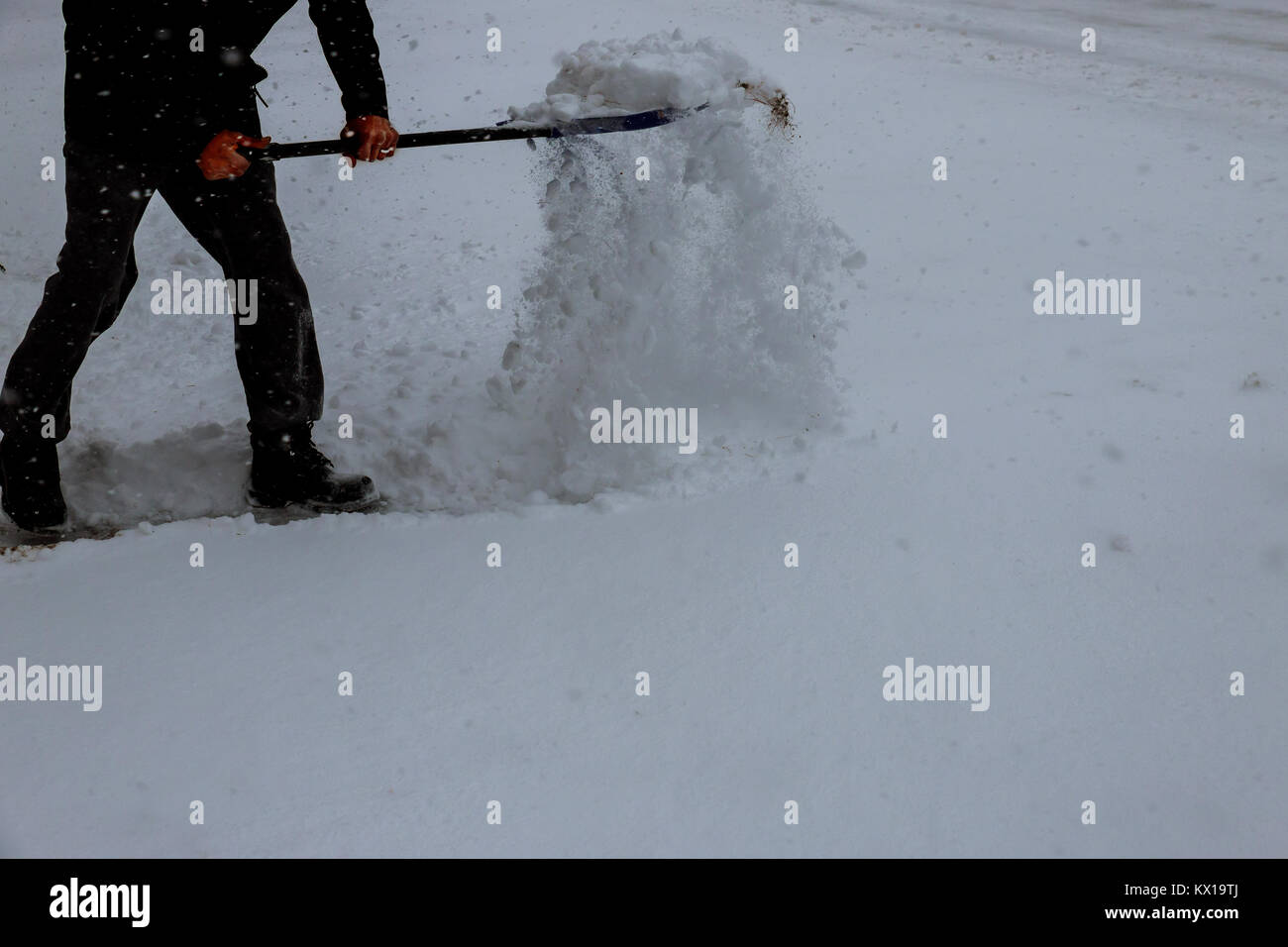 L'uomo con la Pala da neve pulisce i marciapiedi in inverno. L'inverno. L'uomo la rimozione di neve con una pala Foto Stock