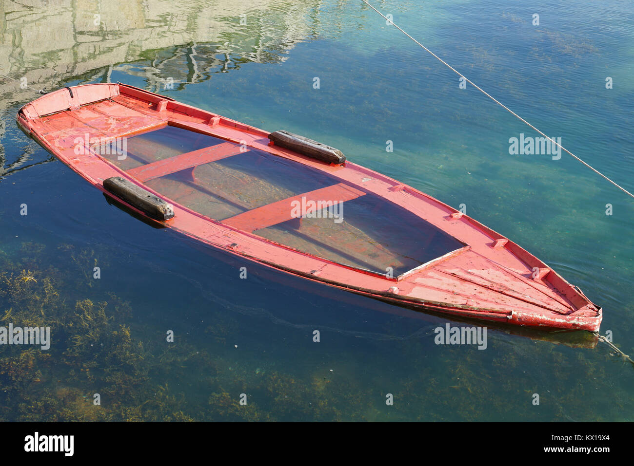 Affondato vecchio rosso skiff in una baia nell'oceano che mostra gli Evanescence Foto Stock