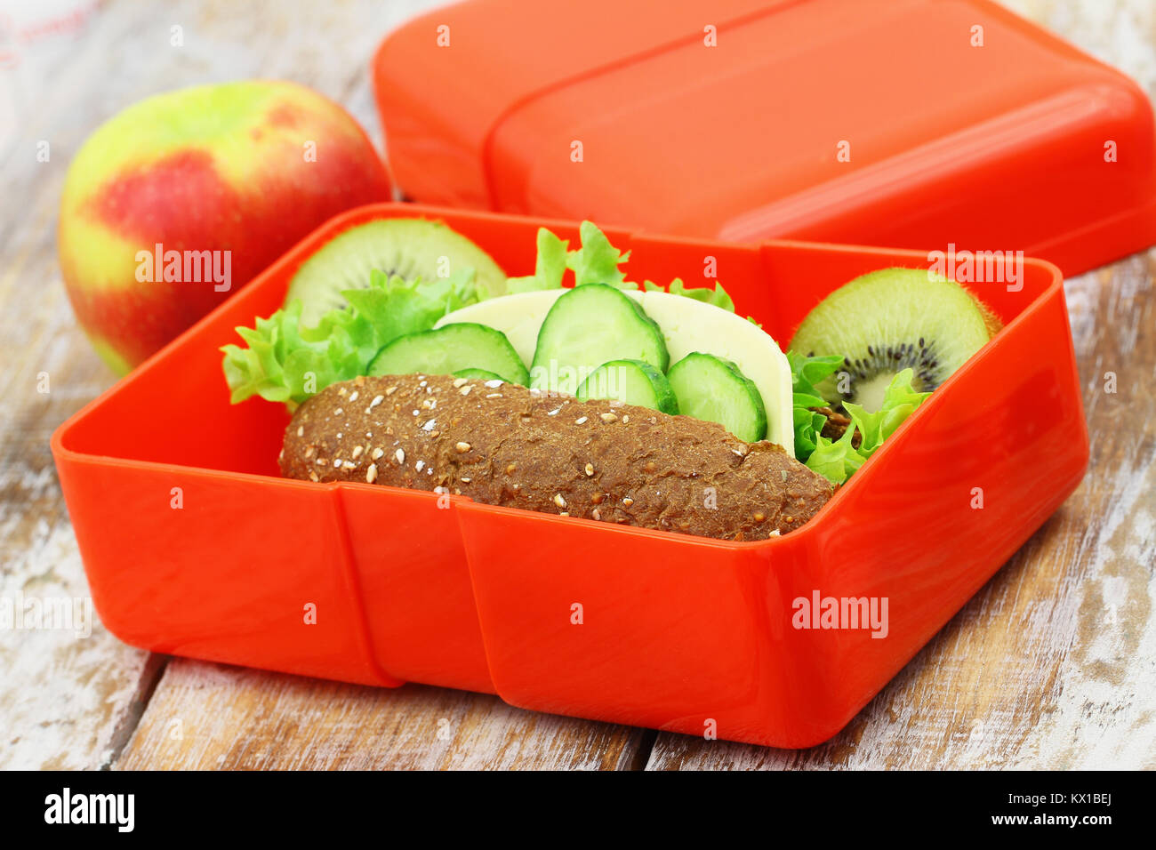 Pranzo sano scatola contenente formaggio marrone sandwich, croccante di carote e kiwi Foto Stock