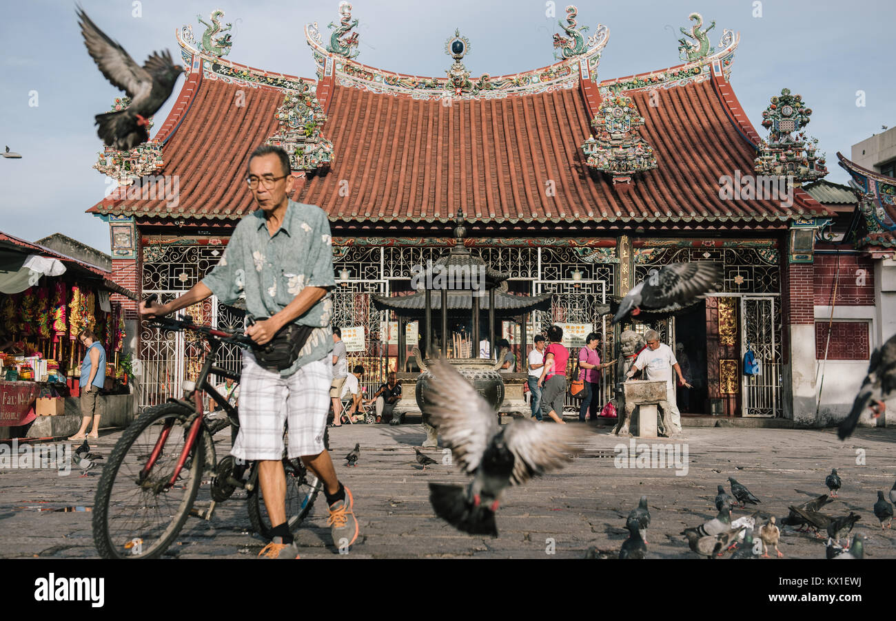 Un uomo cammina davanti a un Tempio Taoista chiamato Kuan Yin Teng, anche noto come il Tempio della Dea della Misericordia in Georgetown, Penang, Malaysia. Foto Stock