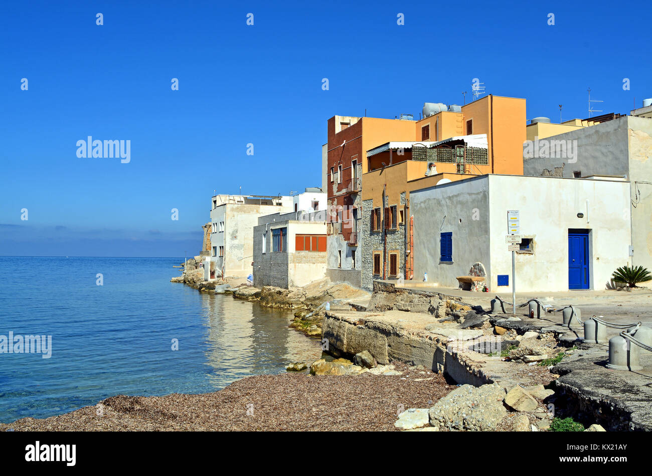 La punta occidentale della città costiera di Trapani in Sicilia (Italia);  semplici case bianche in parte riflessa nel mare, tutti sotto uno splendido  cielo blu Foto stock - Alamy