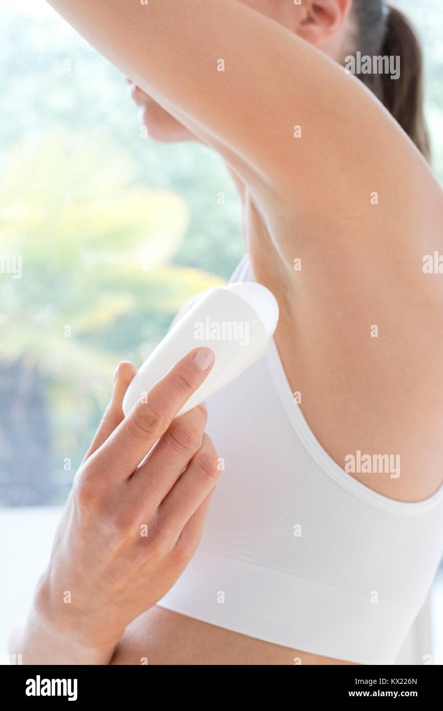Modello rilasciato. Giovane donna applicando le ascelle deodorante, vicino. Foto Stock