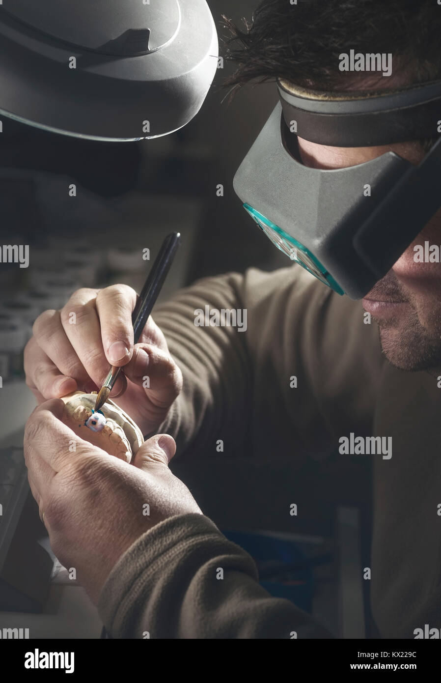 Modello rilasciato. Uomo al lavoro su protesi dentale. Foto Stock