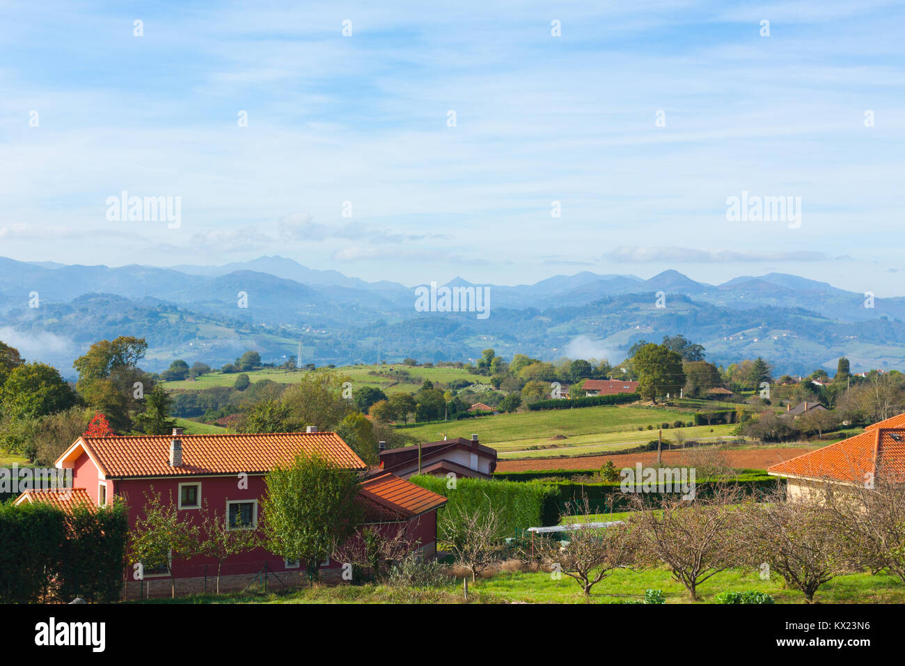 Il paesaggio pastorale del villaggio Escamplero con picchi di montagna in background. Asturias, Spagna Foto Stock