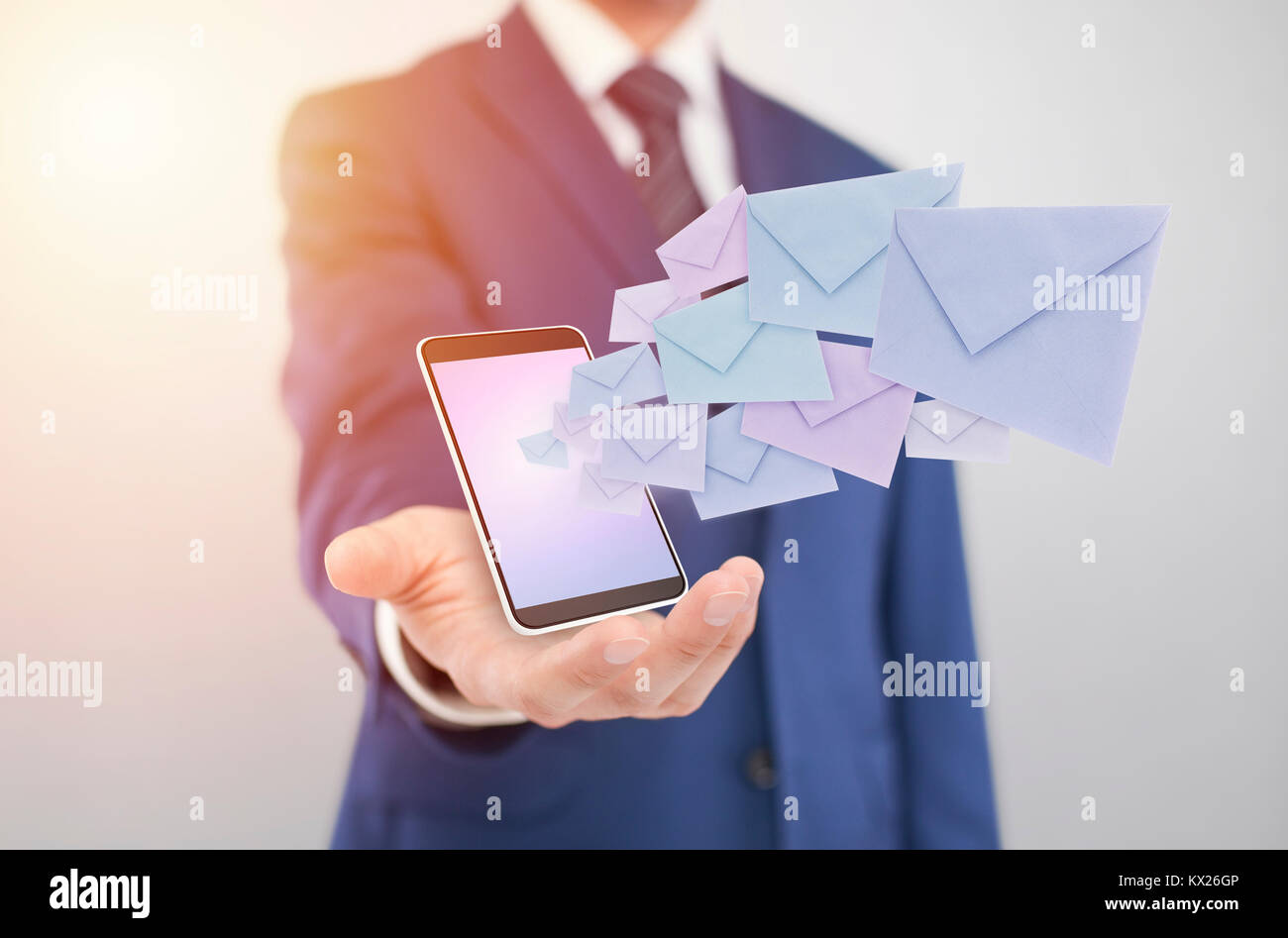 Imprenditore con smartphone con buste in uscita dello schermo Foto Stock