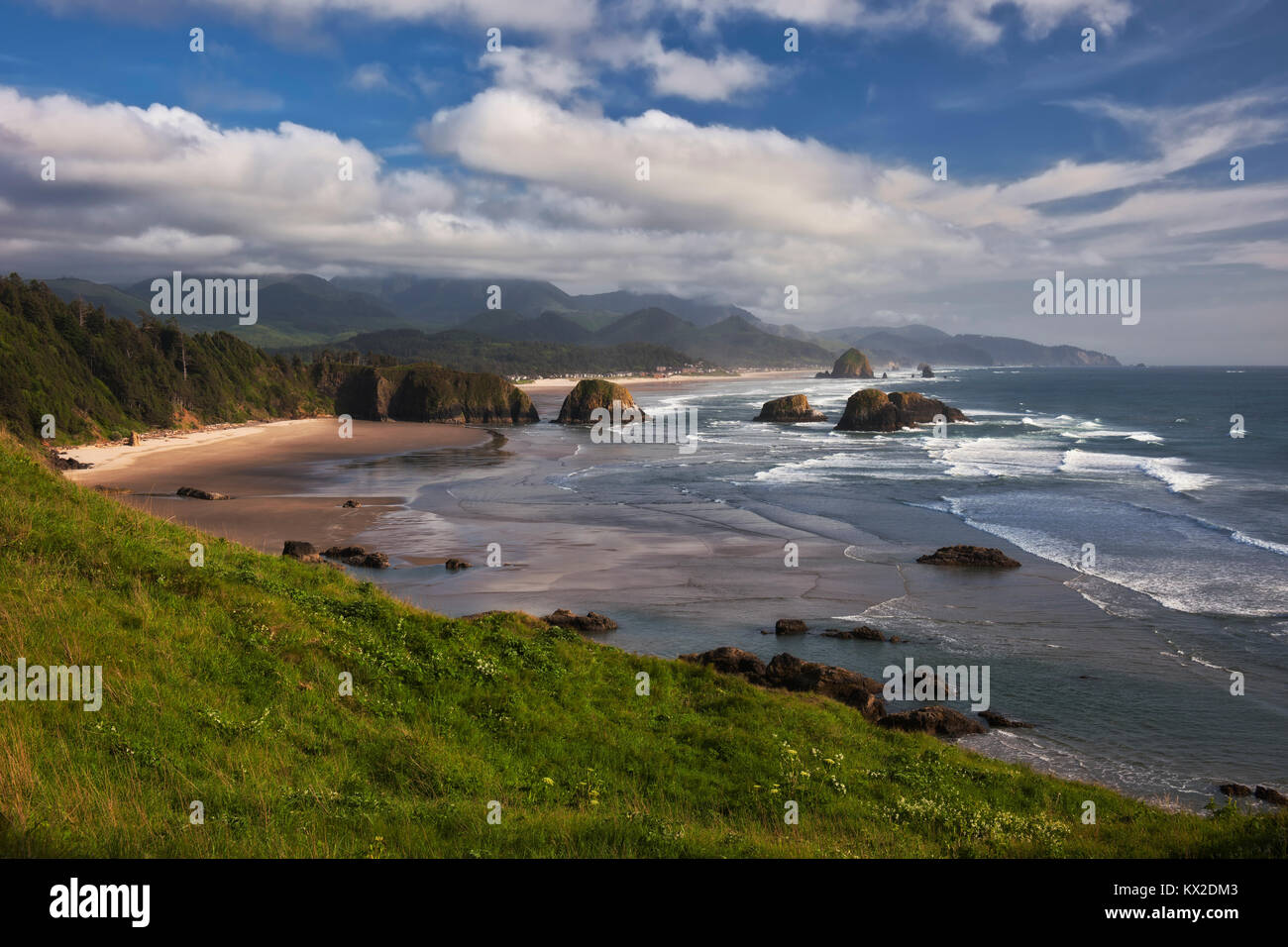 Le nuvole e la nebbia sollevare sopra Neahkahnie Mountain rivelando la vista spettacolare di Cannon Beach e offshore Haystack Rock da dell'Oregon Ecola State Park. Foto Stock