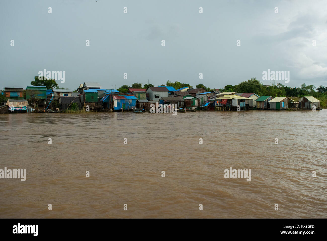 Una piccola bidonville, squatter insediamento di povere case di legno e lamiere grecate, shanties baracche accanto al fiume Mekong, Phnom Penh Cambogia Foto Stock