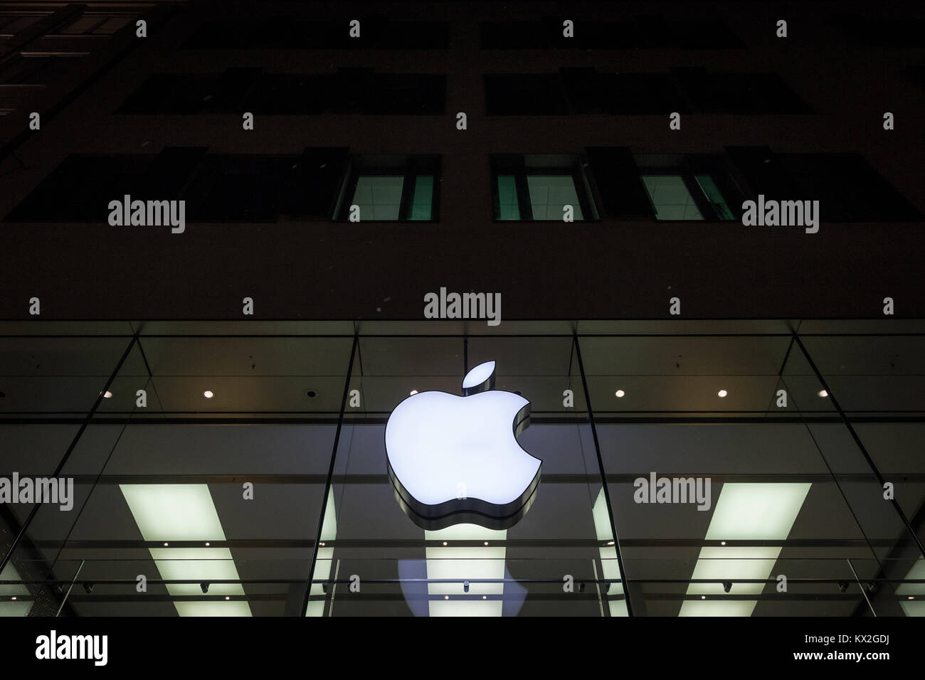 Monaco di Baviera, Germania - 17 dicembre 2017: il logo Apple sul Monaco di Baviera Apple Store presi durante una notte nevosa. Apple Store è una catena di negozi di proprietà e op Foto Stock