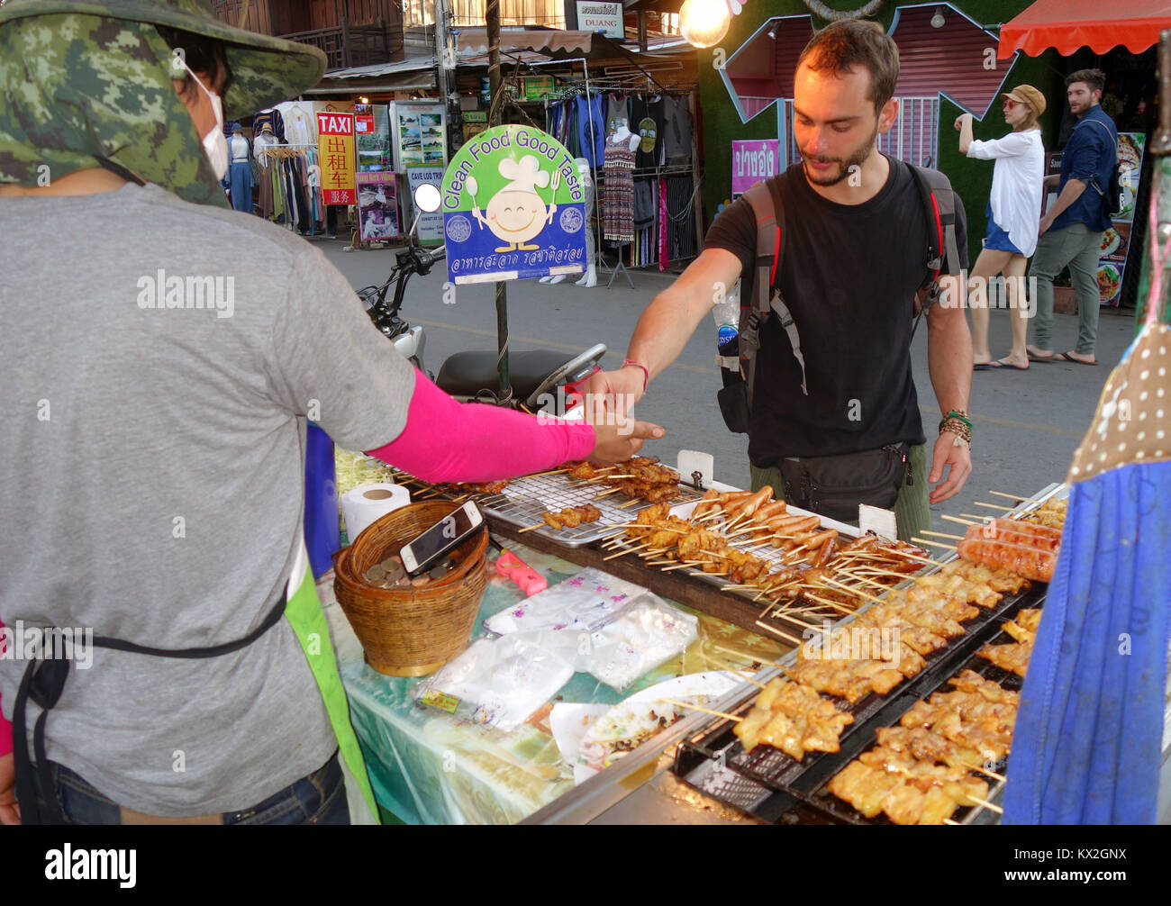 Tourist acquisto di cibo di strada dal fornitore con 'alimenti puliti, buon gusto" segno, Pai, Chiang Mai, Thailandia. No signor o PR Foto Stock