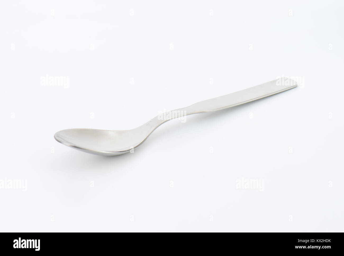 Piccolo vuoto cucchiaio di metallo su sfondo bianco Foto Stock