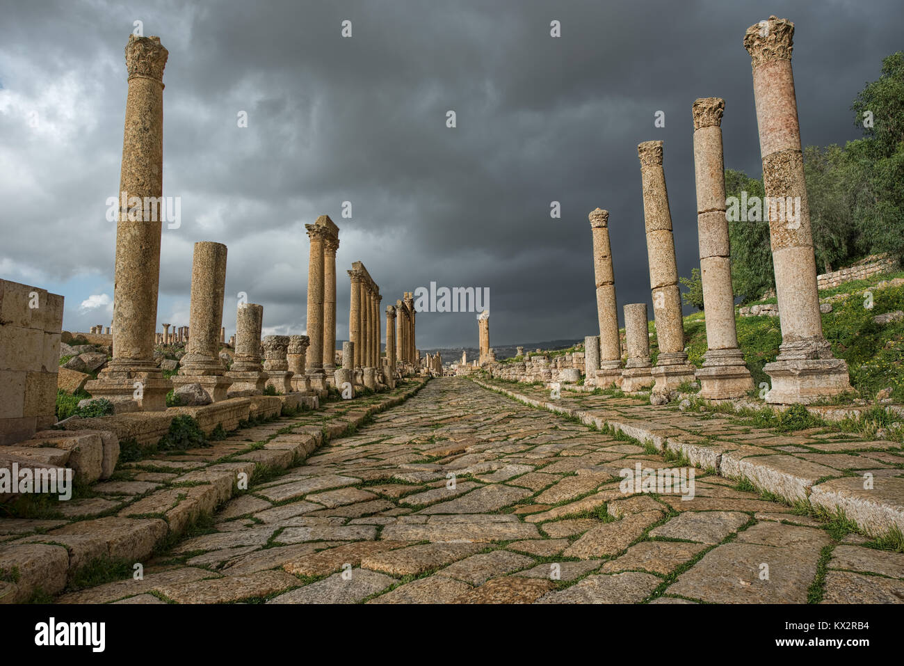 Un collonade street nella città antica di Gerasa dopo una tempesta con il grigio scuro nuvole Foto Stock