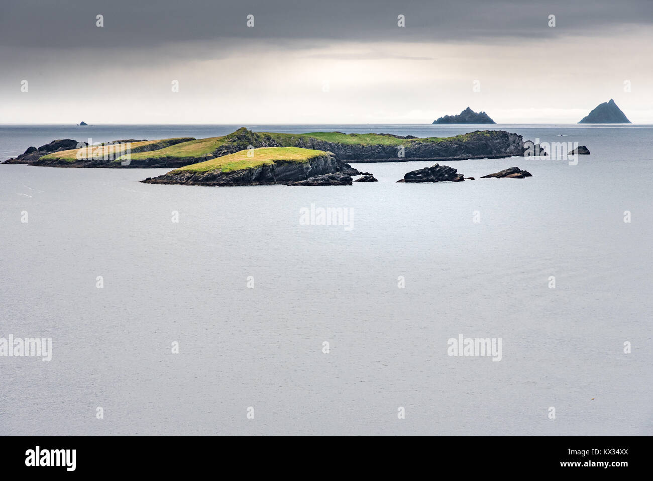 Le Isole Skellig si stagliano all'orizzonte su un mare calmo e un cielo di pioggia Foto Stock