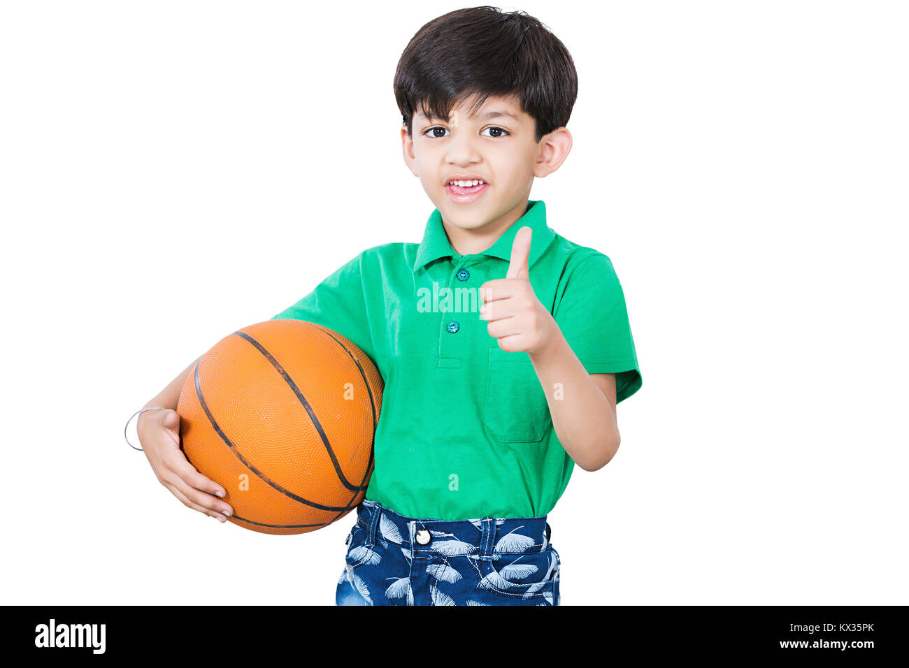 Gioco di allenamento di basket. Bambino sorridente con palla da basket che  mostra il pollice in