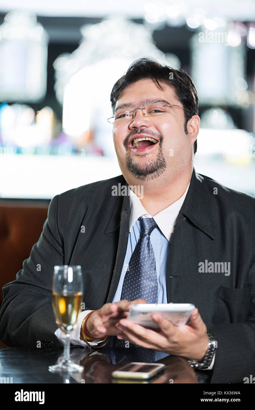 Un uomo d'affari seduta Tabella Text-Message Invio digitale compressa In-Restaurant Foto Stock