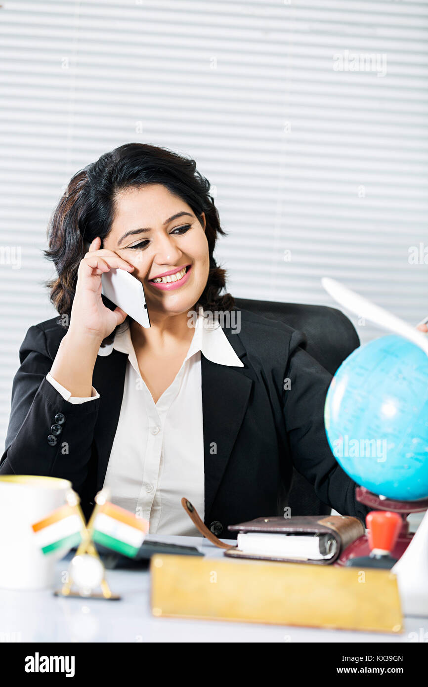 Indian imprenditrice datore di lavoro seduta parlando di Office Phone sorridente Foto Stock