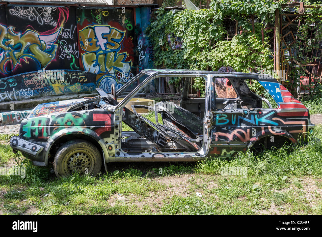 Auto abbandonate coperto di graffiti - Metelkova squat urbana, Lubiana, Slovenia Foto Stock