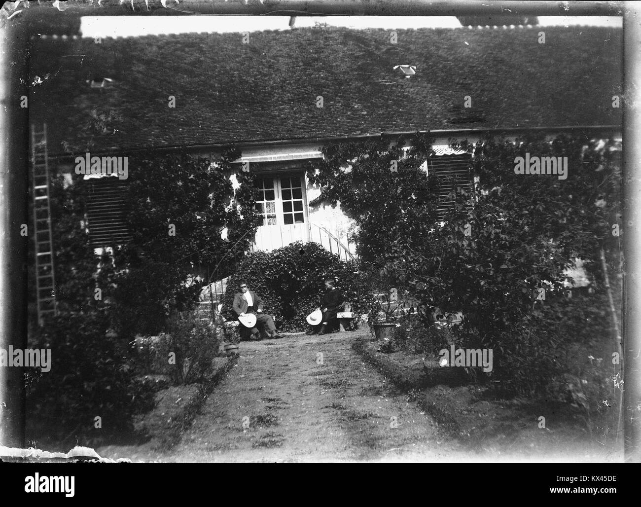 Questa fotografia mostra una casa e il suo giardino, catturati nella collezione Fonds Berthel. L'immagine riflette il design e il layout di proprietà private e giardini durante il periodo. Foto Stock