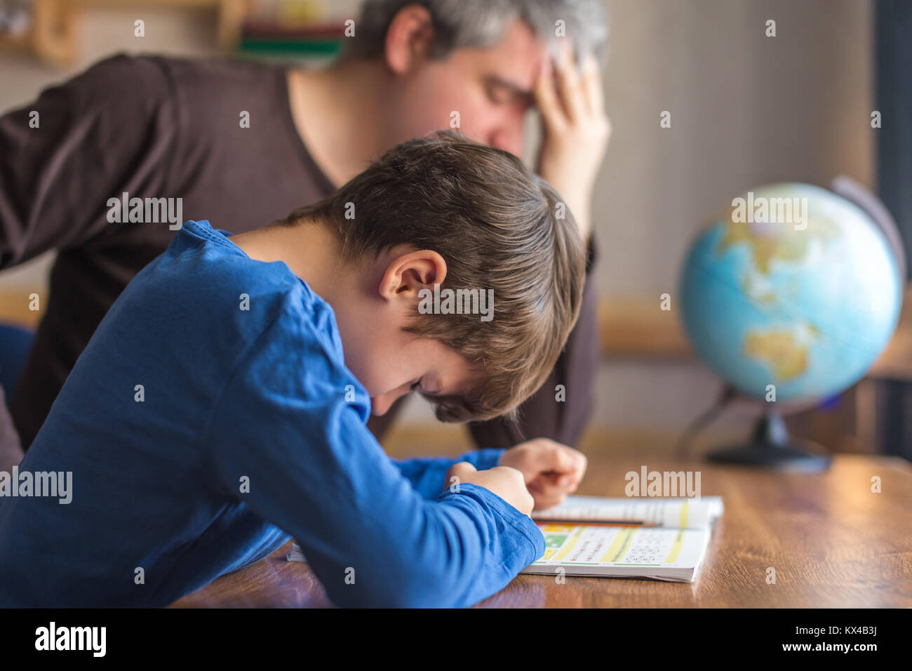 Triste padre stanco sui figli guasto sulla matematica compiti, lo stress Foto Stock