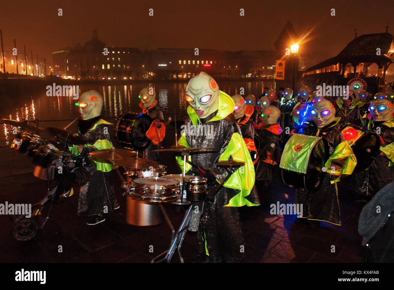 Caratteri strani con fantastiche maschere e costumi sfilano lungo le strette strade durante il carnevale di Lucerna, Svizzera Foto Stock