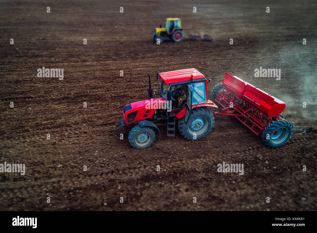 Tilt Shift di vista aerea di trattori lavorando sul campo di raccolto Foto Stock