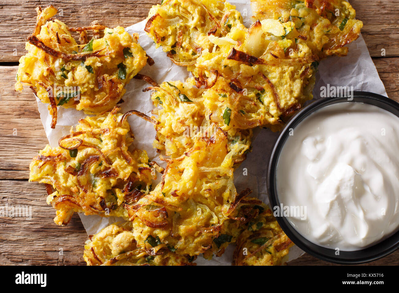 Cipolla croccante Bhajis vegane snack o del motorino di avviamento con yogurt close-up. parte superiore orizzontale vista da sopra Foto Stock