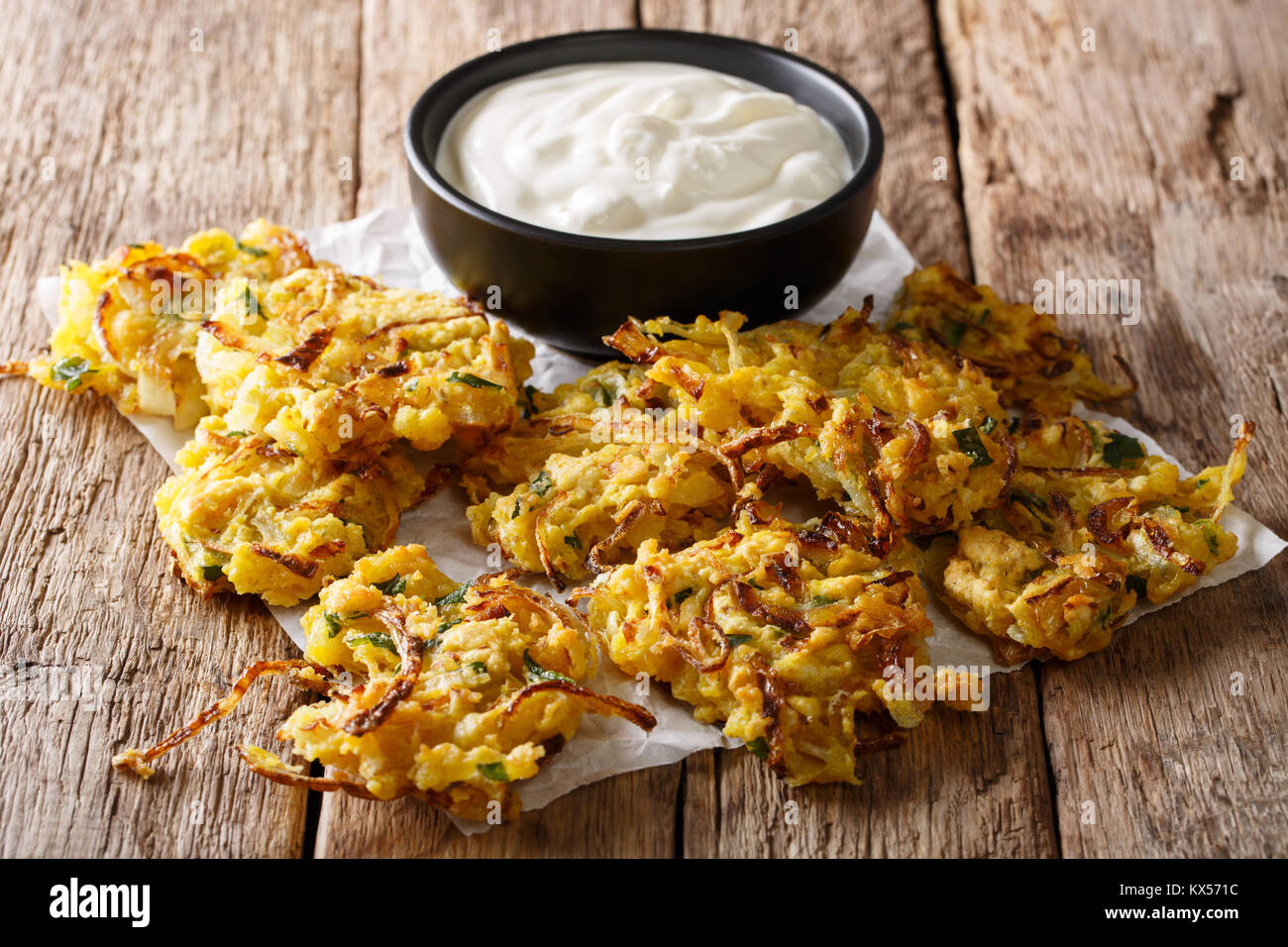 In casa fritto indiano onion bhaji con yogurt vicino sul tavolo orizzontale. Foto Stock