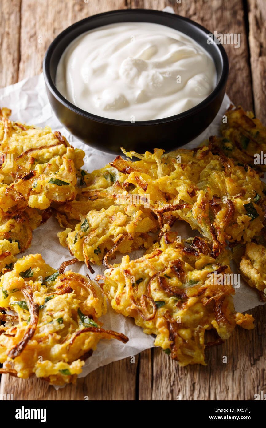 Hot cipolla croccante bhaji e yogurt vicino sul piano verticale. Foto Stock