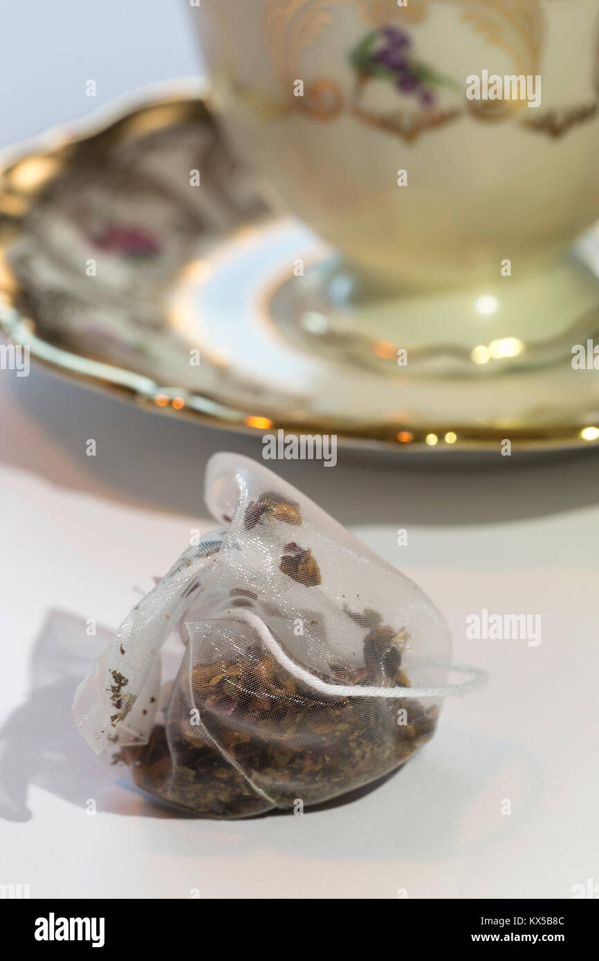 Bustine di The in seta con tazza di porcellana con piattino in background Foto Stock