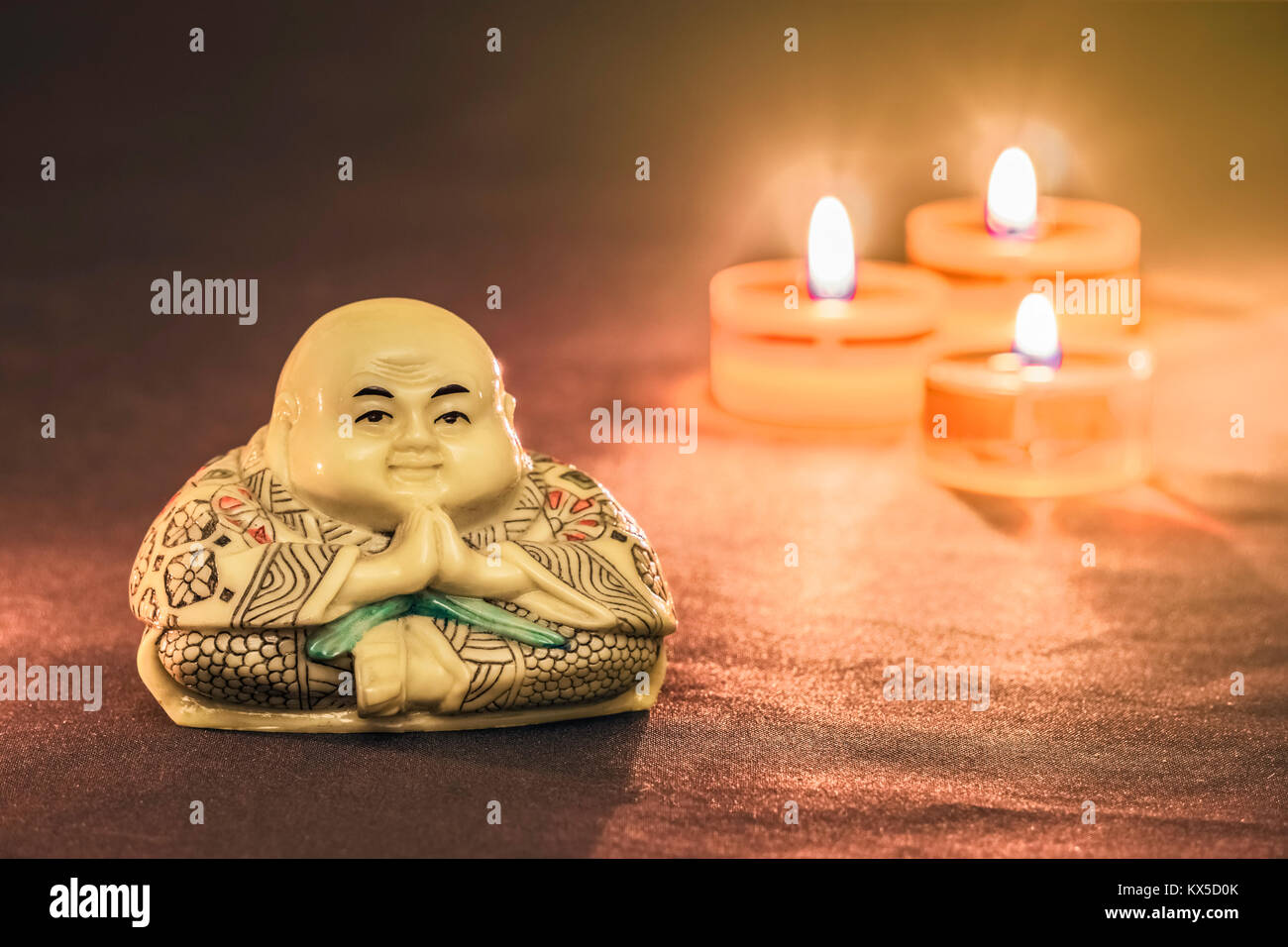 Statua di meditazione Buddha e candele in background. Copia dello spazio. Foto Stock