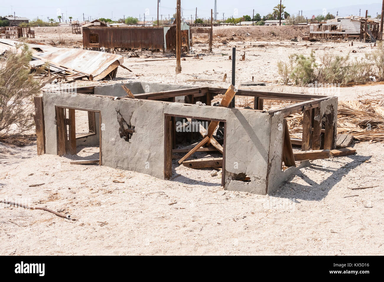 Casa strappato mezzo sepolto nella sporcizia, Salton Sea Beach, California, Stati Uniti d'America. Questo sito non esiste più. Foto Stock