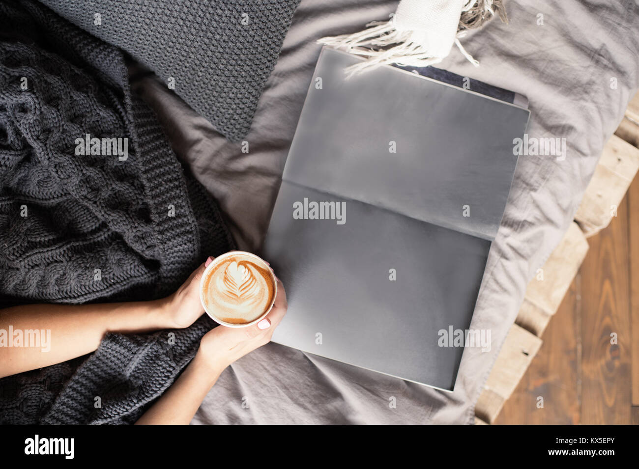 Vista dall'alto il caffè del mattino a letto coperta di lana e spazio vuoto le pagine di una rivista Foto Stock