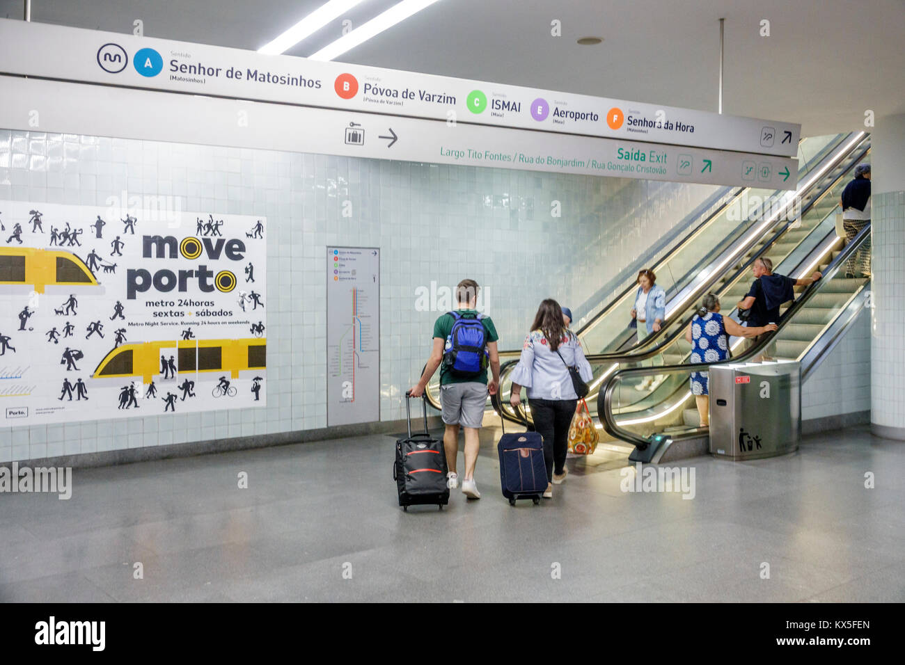 Porto Portogallo, Metro do Porto, metropolitana, trasporti pubblici, stazione di Trindade, scala mobile, segnale, uscita, direzione, linee, ispanico, immigrati immigrati, coppia, rollin Foto Stock