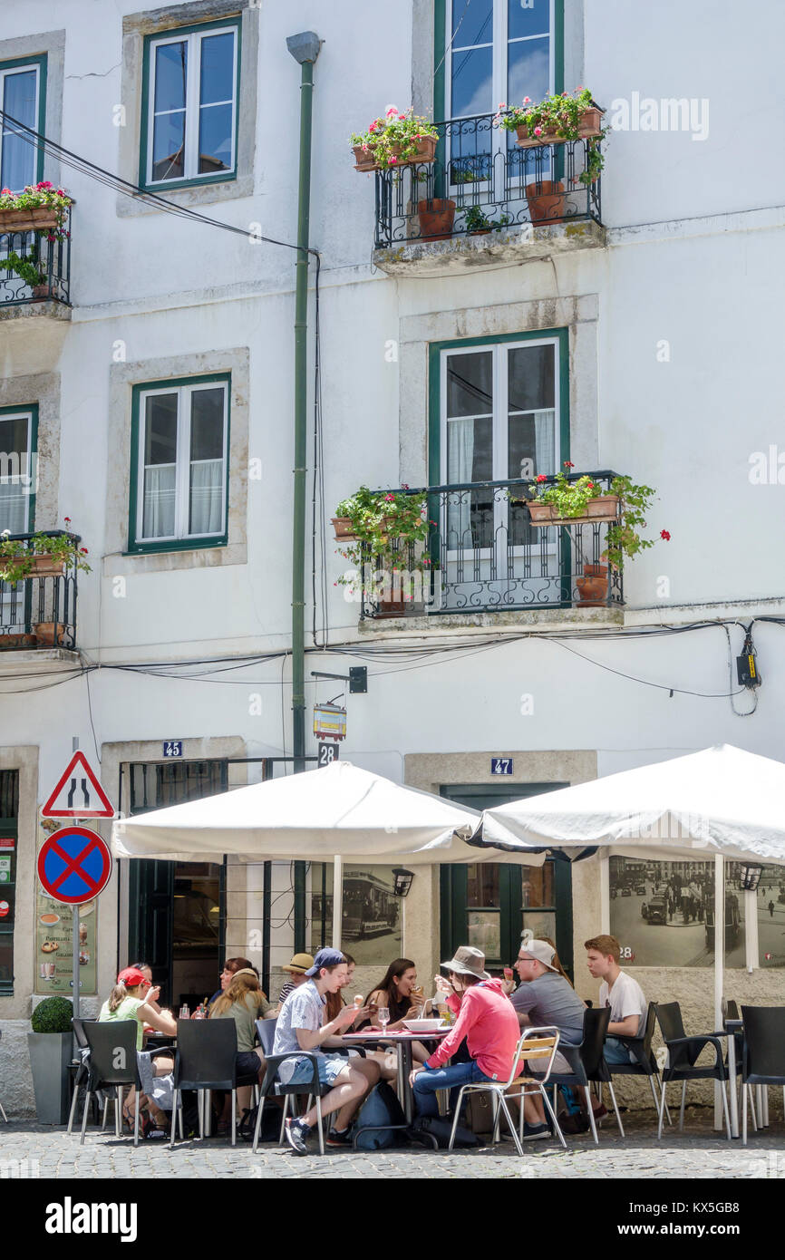 Lisbona Portogallo,Alfama,quartiere storico,28 cafe,al fresco,marciapiede fuori tavoli strada da pranzo,ombrellone da pranzo,tavolo,balcone,flower box,uomo Foto Stock